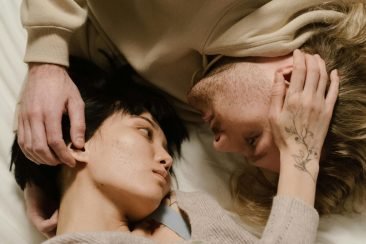 Pareja acostados mirándose a los ojos